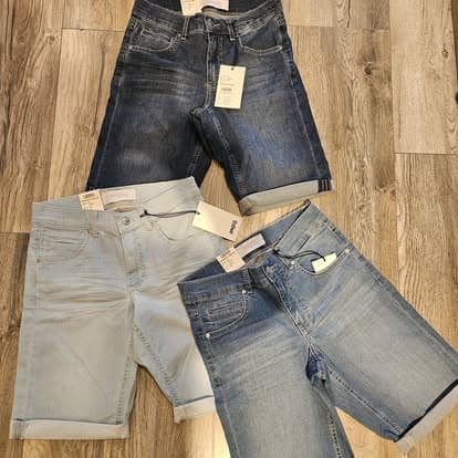 Drie jeans op een houten vloer